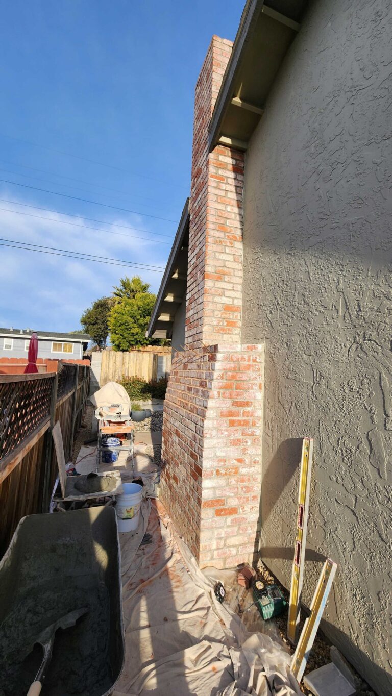 Red brick chimney under construction showing scope and site access challenges in residential setting